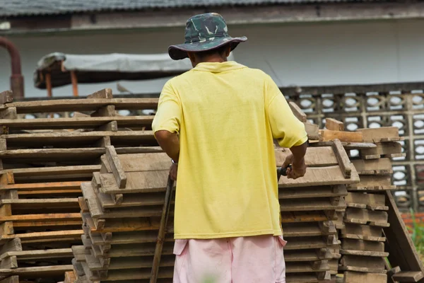 Obrero hombre levanta la madera de la producción de ladrillos en Tailandia —  Fotos de Stock