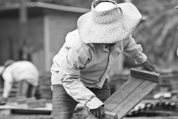 Mujer trabajadora levanta la madera de la producción de ladrillos en Tailandia —  Fotos de Stock