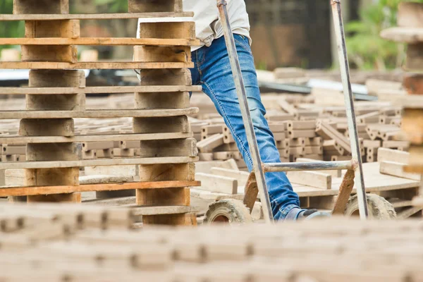 Mannen arbetare lyfter trät av produktionen av tegelstenar i thailand — Stockfoto