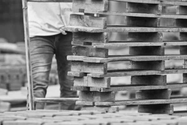 Homem trabalhador levanta a madeira de produção de tijolos na Tailândia — Fotografia de Stock