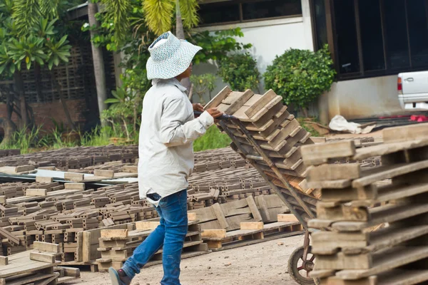 Kvinna arbetare lyfter trät av produktionen av tegelstenar i thailand — Stockfoto