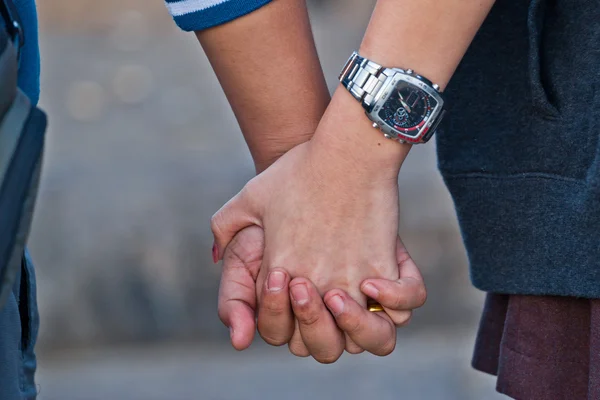 Young beautiful stylish couple in love holding hands — Stock Photo, Image