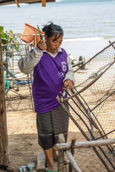 Woman fishermen is weaving fish-trap — Stock Photo, Image