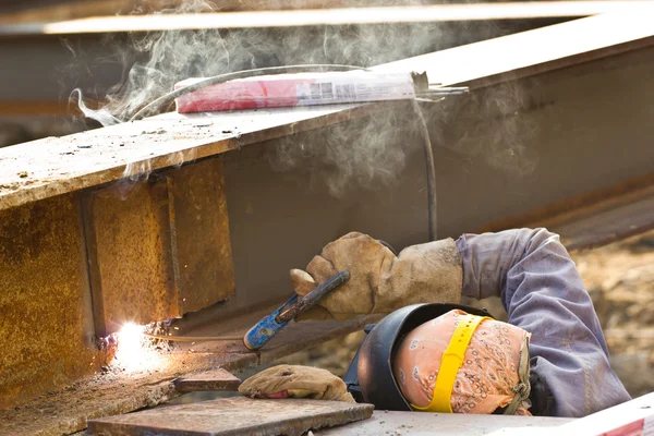 Outdoor werknemer met beschermend masker lassen metaal en sparks — Stockfoto