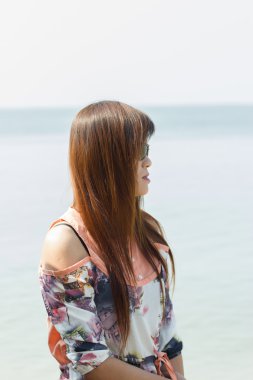 denize bakarak lüks şapkalı kadın