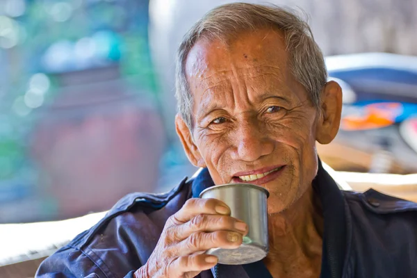 An aged cheerful old man holding a cup of coffee — Stock Photo, Image