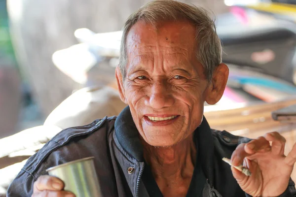 An aged cheerful old man holding a cup of coffee — Stock Photo, Image