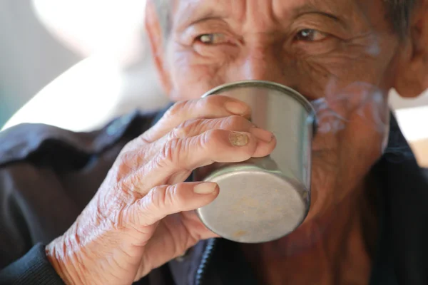 An aged cheerful old man holding a cup of coffee — Stock Photo, Image
