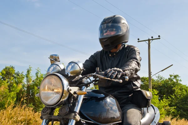 View of a man with a motorcycle on a asphalt road. — Stock Photo, Image