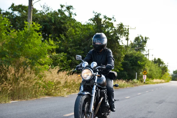 Motociclista en el camino contra el cielo —  Fotos de Stock