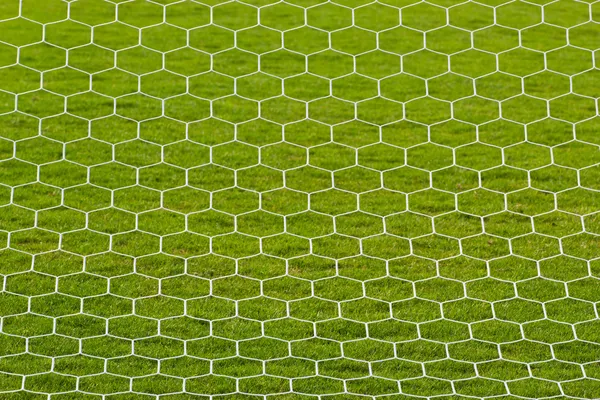 Goalpost net detail with green grass blur in background sports c — Stock Photo, Image