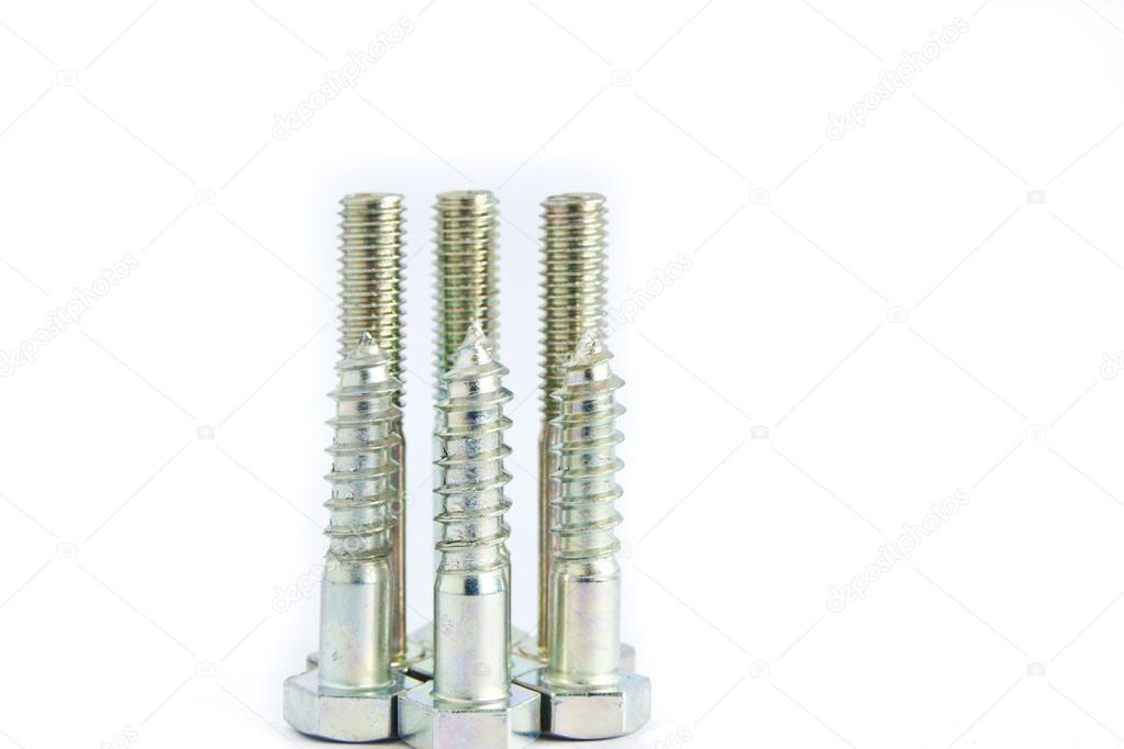 Random pile of hexagonal threaded steel bolts or screws on white