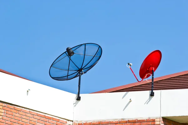 在顶尖屋顶上的碟型卫星天线 — 图库照片