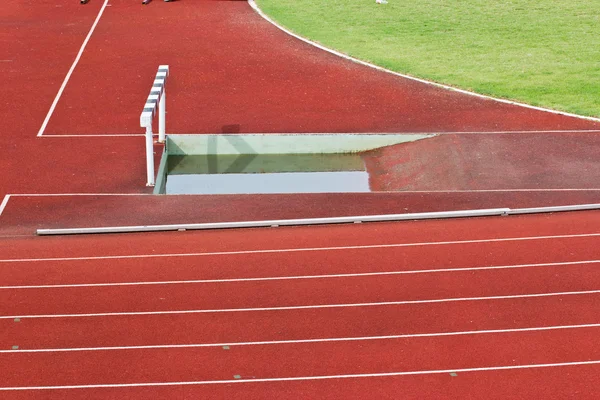 Překážek na červené běžecká dráha pro soutěž. — Stock fotografie