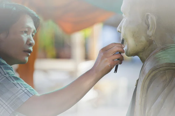 Skulptur verktyg. Artisan skapar huvudet av en buddhistisk mon — Stockfoto