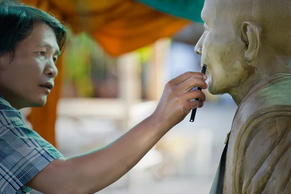 Sochařský nástroj. řemeslník vytváří hlavu buddhistický mon — Stock fotografie