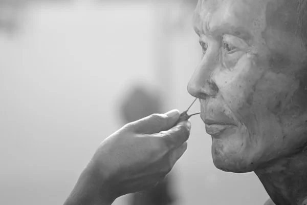 Bildhauerwerkzeug. Handwerker schafft den Kopf eines buddhistischen Mönchs — Stockfoto