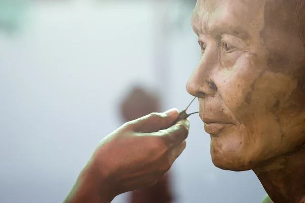 Herramienta de escultura. artesano crea la cabeza de un mon budista —  Fotos de Stock