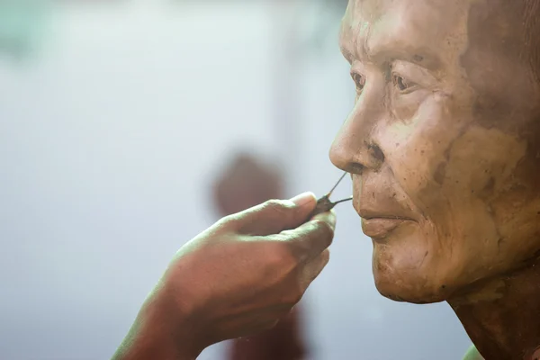 Herramienta de escultura. artesano crea la cabeza de un monje budista — Foto de Stock