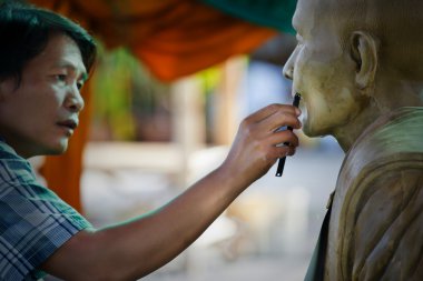Sculpture Tool. artisan creates the head of a Buddhist mon clipart
