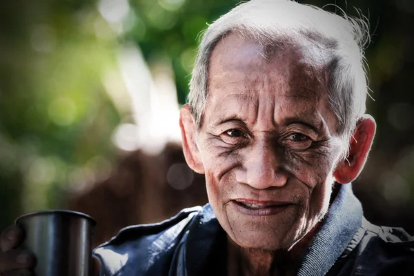 Un anciano alegre anciano sosteniendo una taza de café —  Fotos de Stock