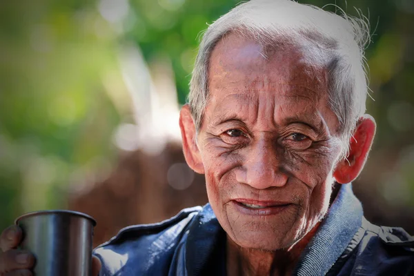 An aged cheerful old man holding a cup of coffee — Stock Photo, Image