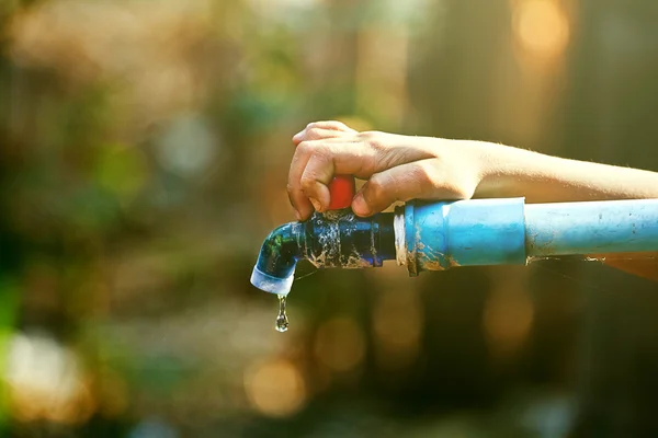 Hand hält Wasserhahn im Freien mit Schlauch — Stockfoto