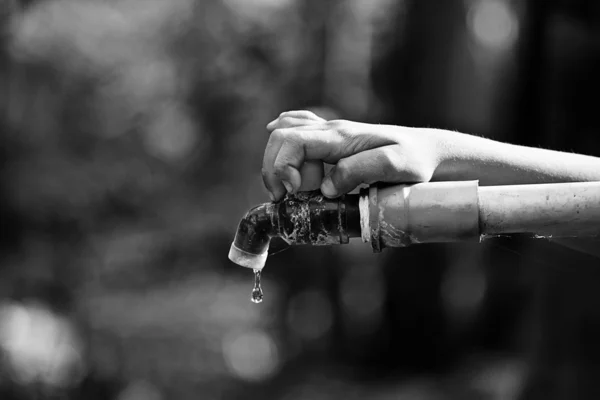 Hand hold outdoor water tap with tube — Stock Photo, Image