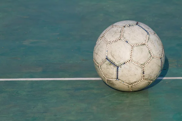 Pelota de fútbol usada antigua sobre asfalto agrietado —  Fotos de Stock