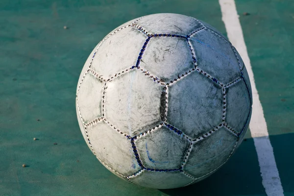 Vecchio calcio usato o pallone da calcio su asfalto incrinato — Foto Stock