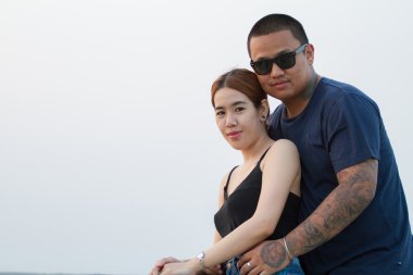 Genç mutlu çifte sarılma ve gülüyor.