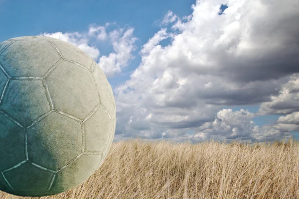 Pelota de fútbol usada antigua sobre asfalto agrietado —  Fotos de Stock