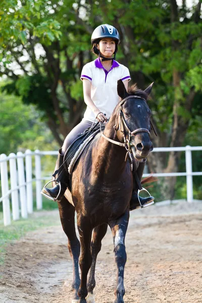 Mooie tiener meisje in bruin jurk bruin paard rijden — Stockfoto