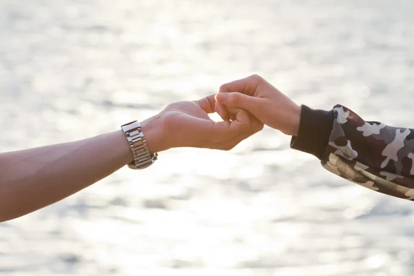 Ungt par i kärlek hålla händer ute i solnedgången — Stockfoto