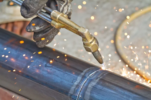 Trabajador usando cortador de antorcha para cortar a través de metal — Foto de Stock