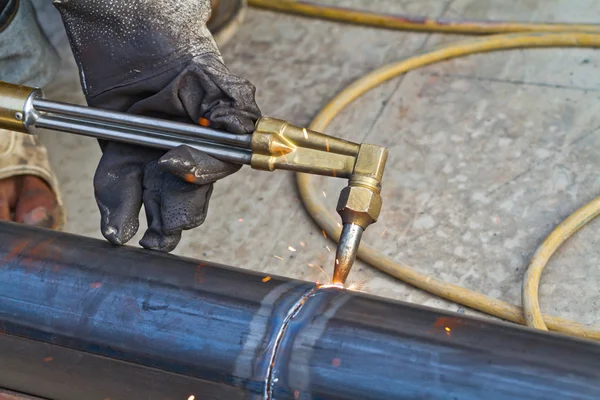 Trabajador usando cortador de antorcha para cortar a través de metal — Foto de Stock