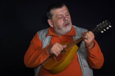Beyaz tenli üst düzey müzisyenin mandolin çalarkenki portresi.