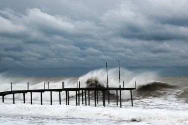 Fırtınalı bir denizin kıyısındaki eski metal iskele. 