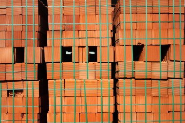 İnşaatta yığınla kırmızı tuğla var.