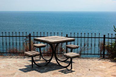 Empty table with four seats in a seaside park