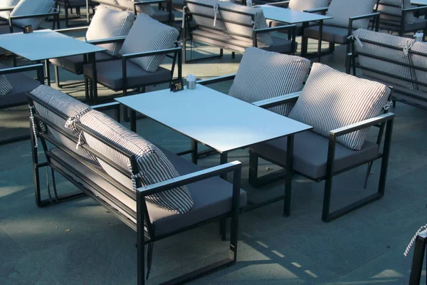 Empty chairs and tables in an outdoor restaurant