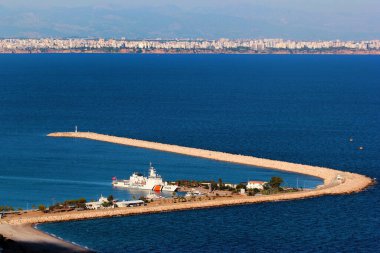 Antalya, Türkiye - 25 Eylül 2022: Tunektepe dağından görüldüğü üzere şehrin batı kesimindeki Konyaalti limanındaki sahil güvenlik gemisi.