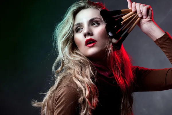 Portrait of beautiful woman with makeup brushes — Stock Photo, Image