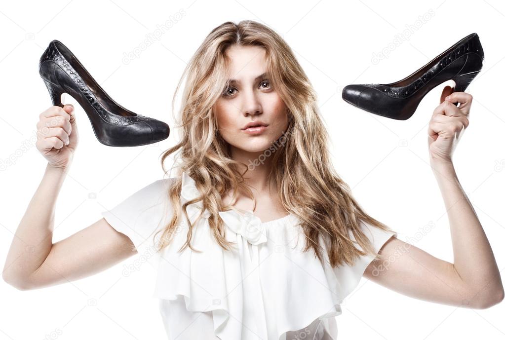 Fashion studio shot of shopping girl holding a black high heel s