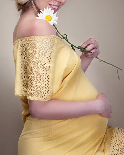 Mujer embarazada sosteniendo flor de primavera —  Fotos de Stock