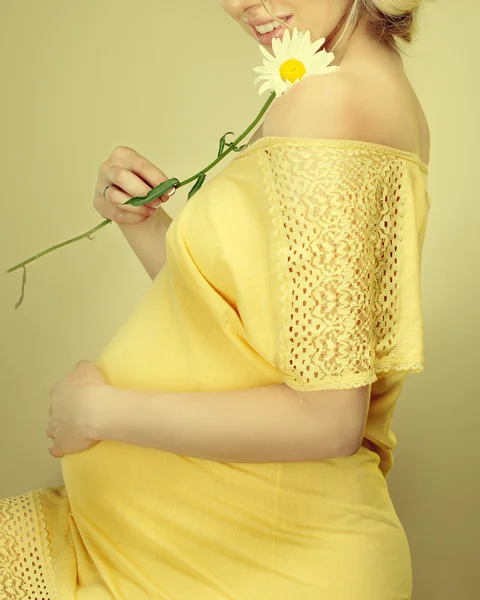 Mujer embarazada sosteniendo flores de primavera —  Fotos de Stock