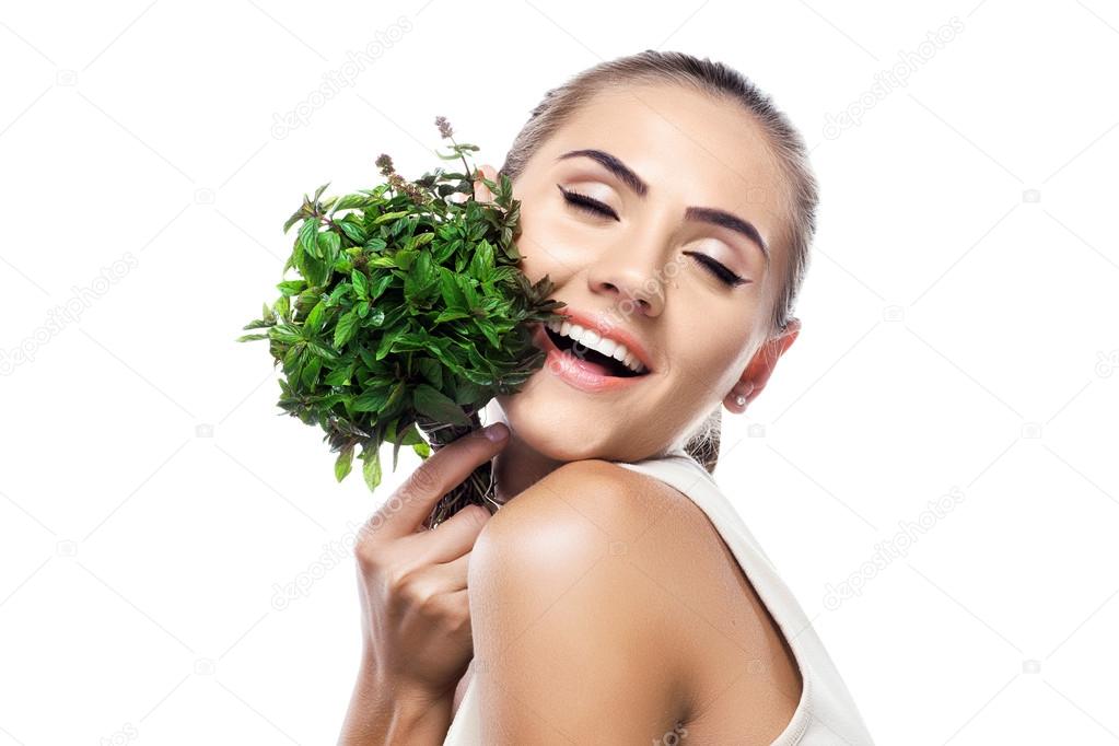 Portrait of happy young woman with a bundle of fresh mint