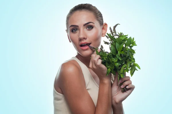 Happy young woman with a bundle of fresh mint. — Stock Photo, Image