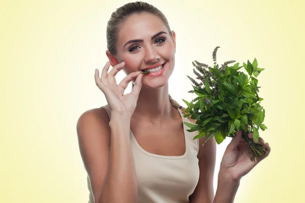 Happy young woman with a bundle of fresh mint. — Stock Photo, Image