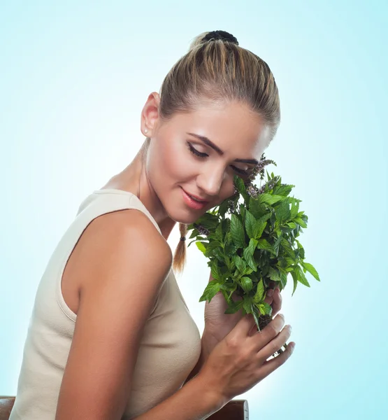 Happy young woman with a bundle of fresh mint. — Stock Photo, Image